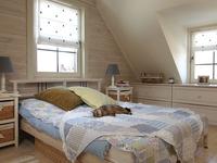 Sypialnia na poddaszu w stylu prowansalskim. Drewno w sypialni